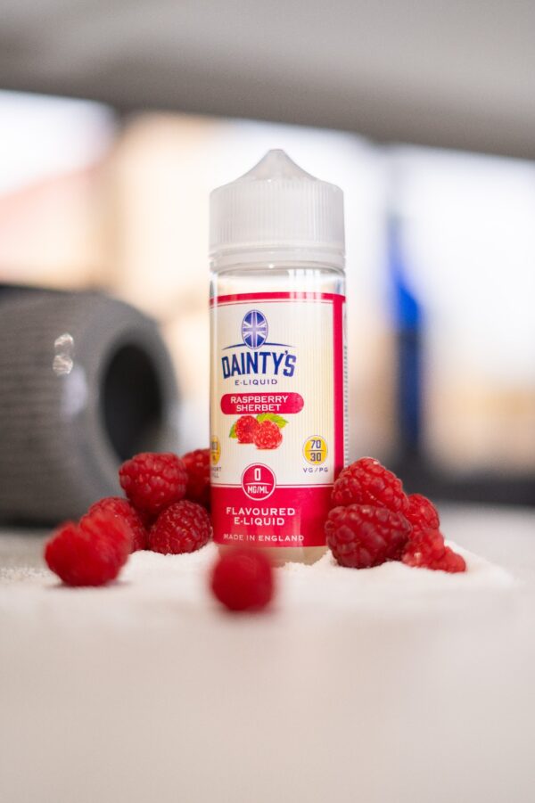 Dainty's 100ml E-Liquid Shortfill on a table with fresh raspberries